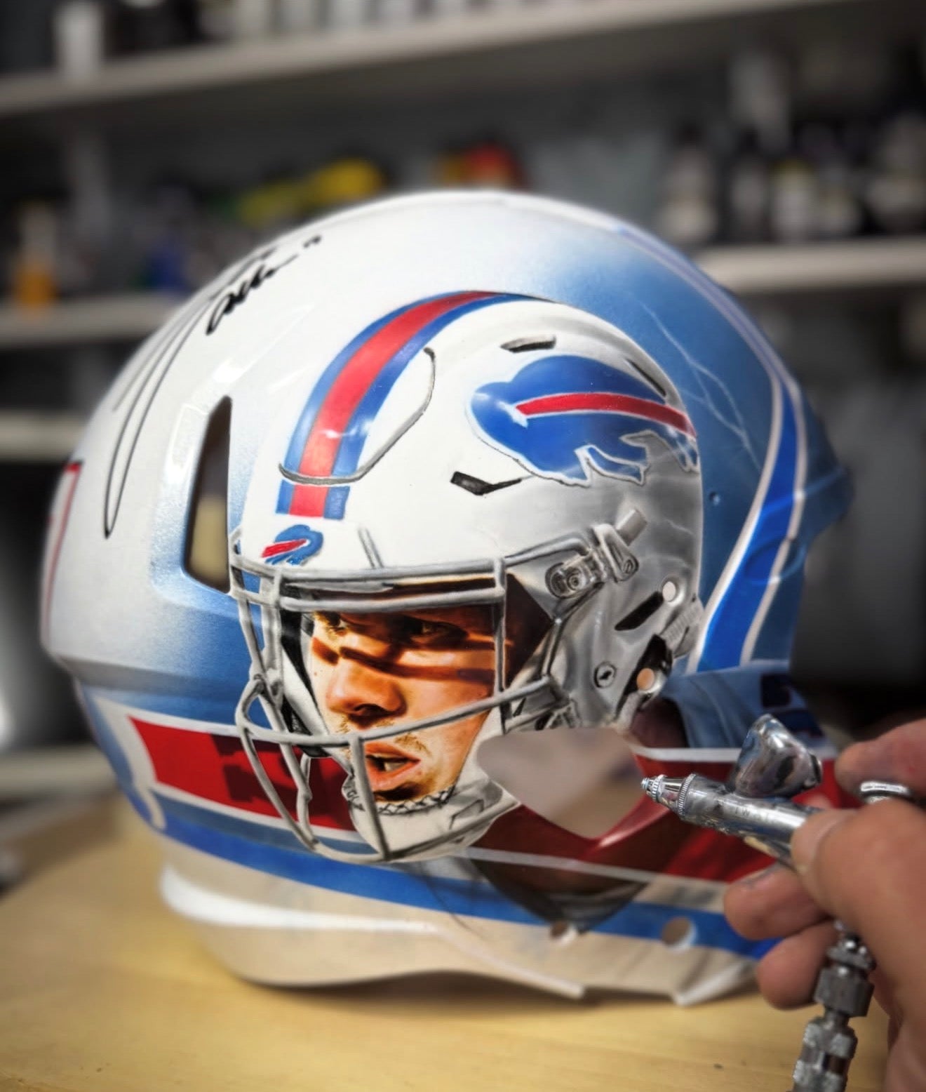 Grizzly Airbrush painting a Josh Allen portrait on a Buffalo Bills helmet